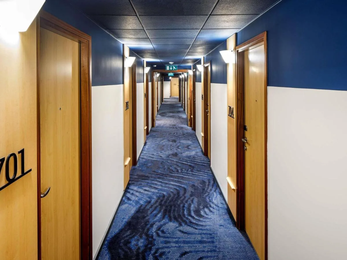 a hallway with blue walls and a long aisle at ibis London Blackfriars in London