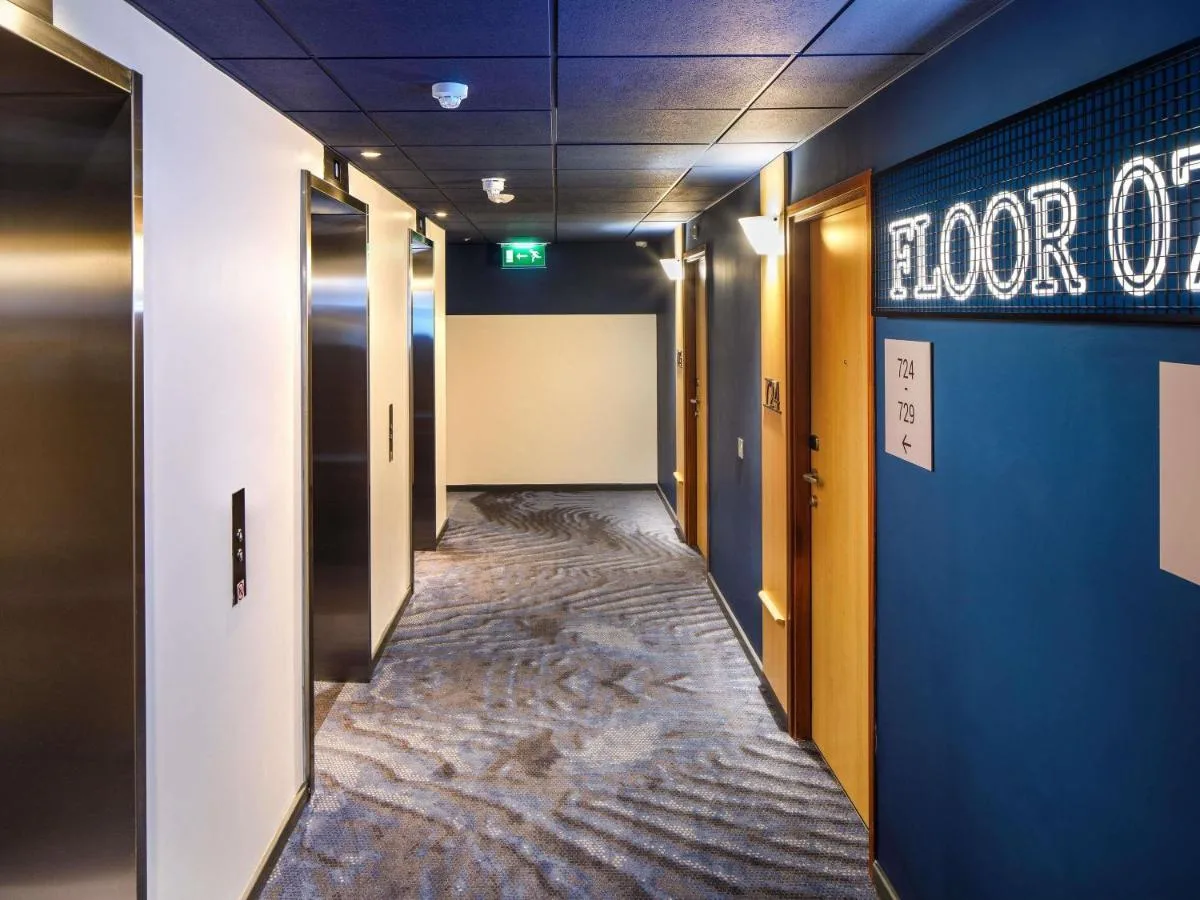 a corridor of a hallway with blue walls and a long aisle at ibis London Blackfriars in London